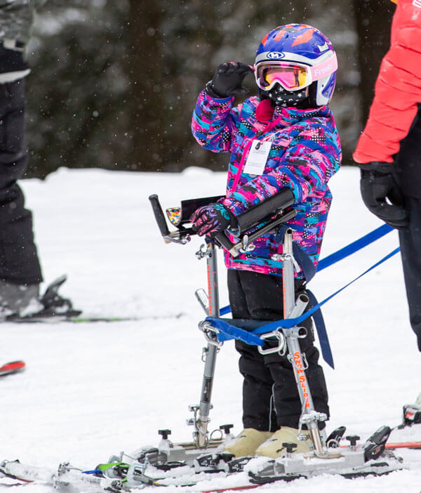 Child skiing with help of an aide